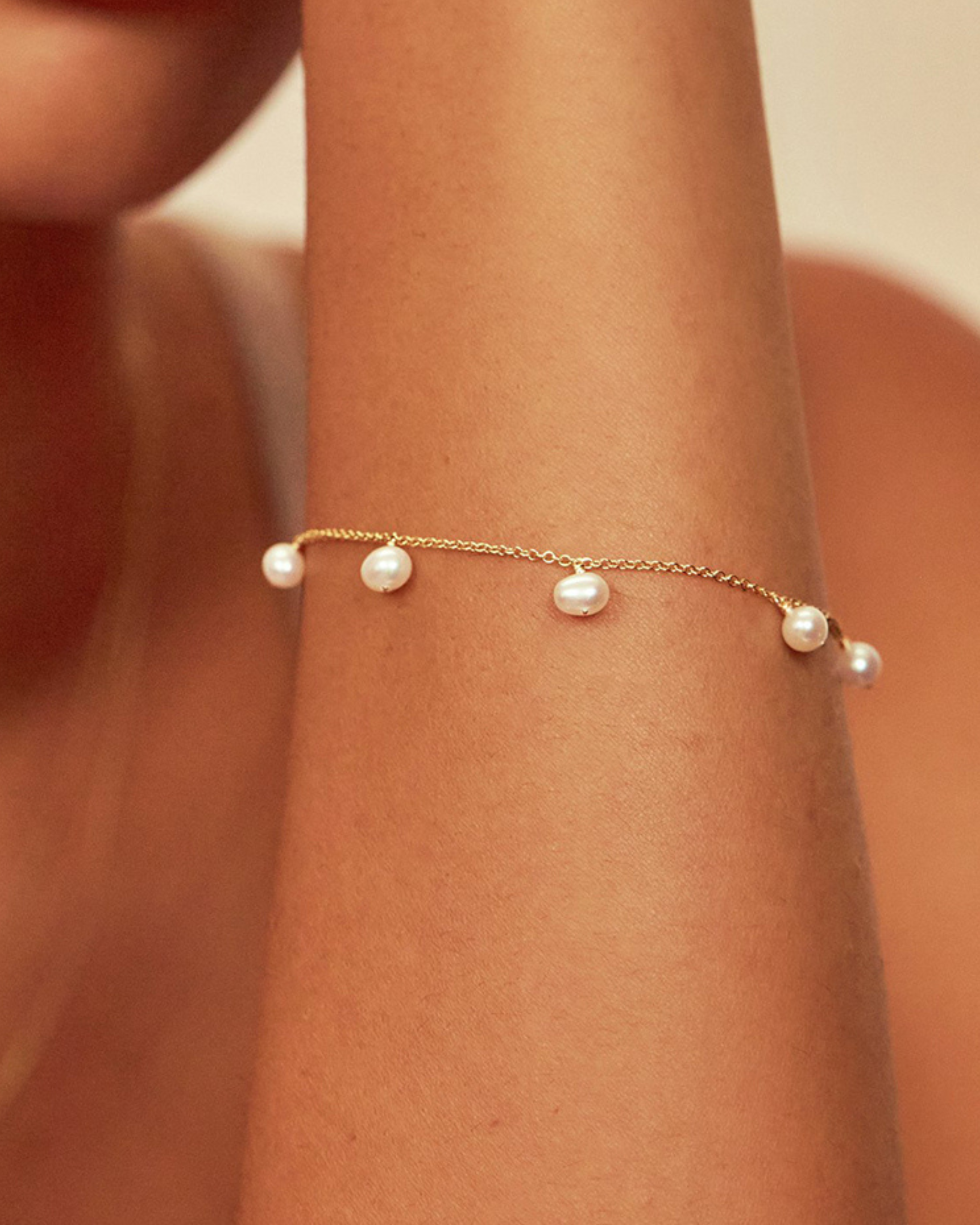 Tragefoto eines vergoldeten Armbandes aus Silber mit Perlen – minimalistisches Design