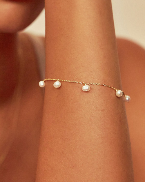 Tragefoto eines vergoldeten Armbandes aus Silber mit Perlen – minimalistisches Design