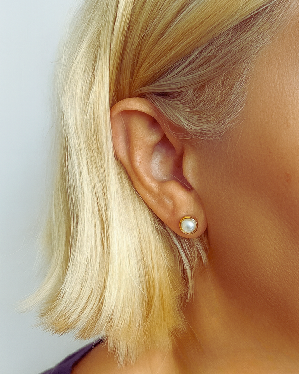 Tragefoto von vergoldeten Perlensteckern – minimalistisches Design