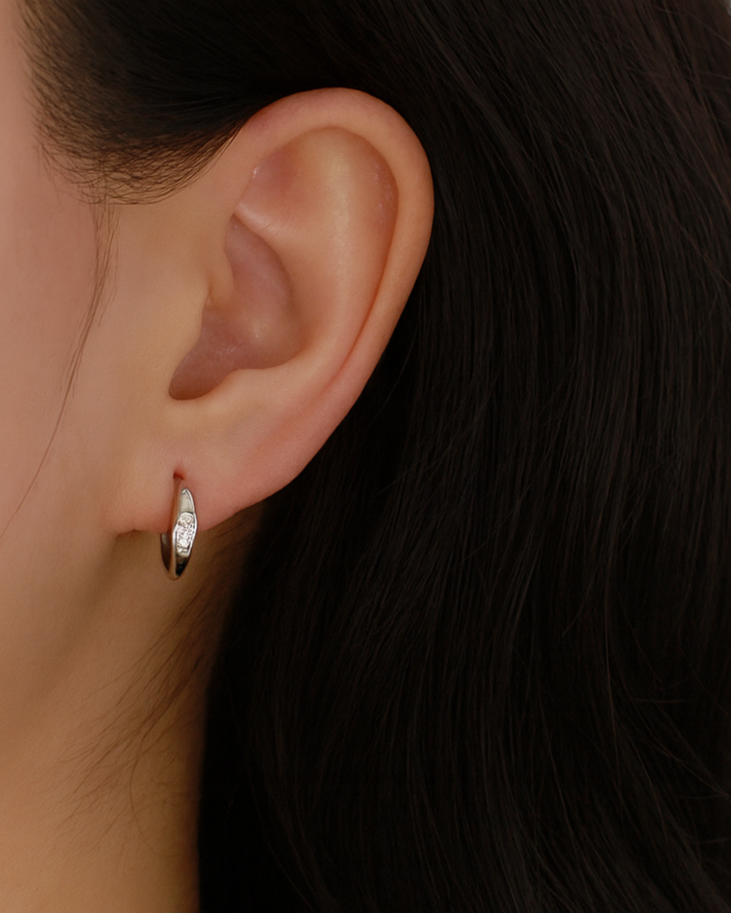 Tragefoto von asymmetrischen Hoops mit Zirkonia Steinen von PERLI.